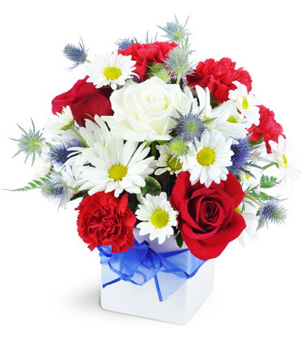 Red, White, and True. An arrangement by Avenue Flowers and Gifts. Red roses, red carnations, and white daisies are topped with blue sea holly and...