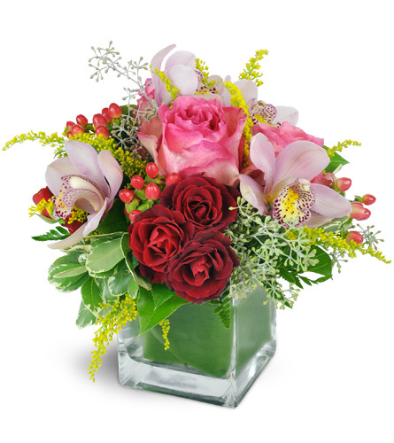 Sweet Melody™. An arrangement by Avenue Flowers and Gifts. Lush Cymbidium orchids and pink roses are beautifully arranged with red spray roses and...
