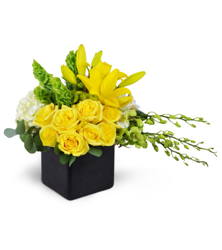 Sensational Smiles™ - Deluxe. An arrangement by Avenue Flowers and Gifts. Yellow roses, Dendrobium orchids, and more are arranged in a ceramic...