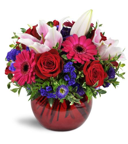 Forever Smitten™ - Deluxe. An arrangement by Avenue Flowers and Gifts. Fuchsia mini Gerbera daisies are romantically arranged with red roses,...