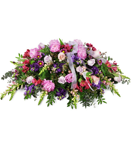 Tender Sentiments Casket Spray™. An arrangement by Avenue Flowers and Gifts. Snapdragons, roses, and peonies are arranged with assorted seasonal...