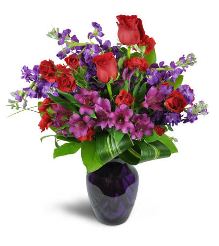 Romance Medley™ - Deluxe. An arrangement by Avenue Flowers and Gifts. Purple Peruvian lilies are arranged with stunning red spray roses and stock....