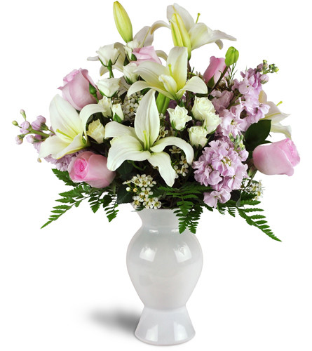 Tender Adoration™. An arrangement by Avenue Flowers and Gifts. Pink roses, white Asiatic lilies, spray roses, and more are arranged in a glass vase..
