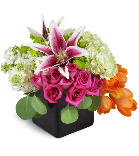 Vibrant Delight™ - Deluxe. An arrangement by Avenue Flowers and Gifts. Roses, tulips, hydrangea, and more are arranged in a ceramic vase. Upgrade...