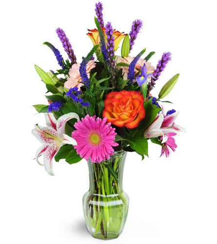 Jazzy Splash™. An arrangement by Avenue Flowers and Gifts. Gerbera daisies, roses, lilies, and more are arranged in a glass vase..