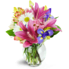 Sweet Symphony™ - Premium. An arrangement by Avenue Flowers and Gifts. Mauve lilies, blue iris, pink lisianthus, and more are arranged in a fluted...