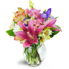 Sweet Symphony™ - Deluxe. An arrangement by Avenue Flowers and Gifts. Mauve lilies, blue iris, pink lisianthus, and more are arranged in a fluted...